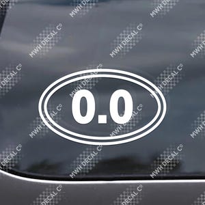 May include: White oval sticker with the number "0.0" inside a double border. The sticker is on a dark surface, and the text "MWH DECAL CO" is repeated around the edges.