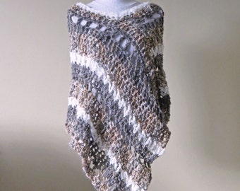Puede incluir: Un poncho de ganchillo en tonos grises, marrones y blancos, exhibido en un maniquí. El poncho tiene un patrón de encaje y una forma triangular. El texto "Crystal Bear Designs" es visible en la parte superior de la imagen, y la palabra "Pattern" es visible en la parte inferior.