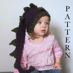 May include: A child wearing a purple and green crocheted dragon hat with a long tail. The hat has a pointed top and a long, flowing tail. The child is wearing a pink and white striped shirt and blue jeans. The text "PATTERN" is written vertically on the right side of the image.