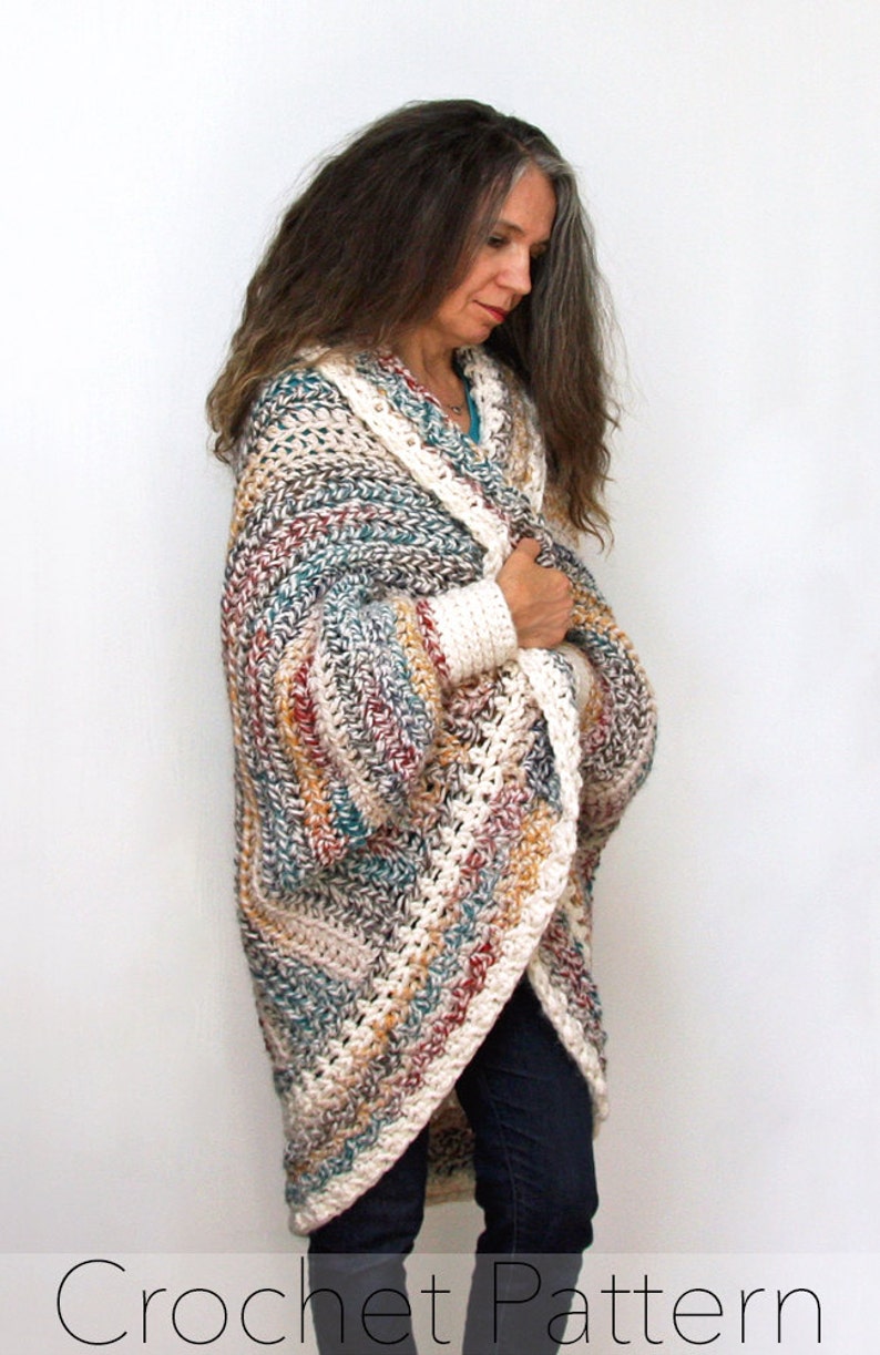 May include: A crocheted cardigan with a long, flowing design. The cardigan is made with a multi-colored yarn in shades of brown, beige, white, and teal. The cardigan has a loose fit and a wide, open neckline.