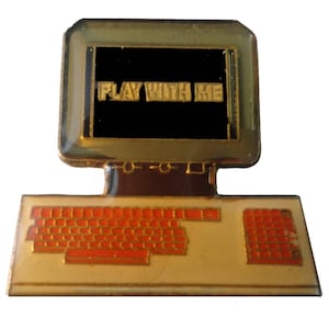 May include: Gold-tone computer pin with a black screen that says "PLAY WITH ME" and an orange keyboard.