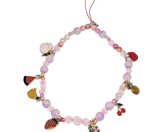 May include: A beaded phone charm with a variety of fruit charms, including a peach, watermelon, banana, strawberry, grapes, pineapple, and cherries. The beads are pink, clear, and iridescent, with a red cord for attachment.