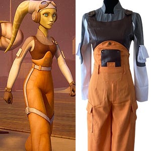 Puede incluir: Un disfraz de cosplay inspirado en un personaje de ciencia ficción. El atuendo incluye un mono naranja con detalles blancos, una parte superior marrón y una camiseta interior blanca. El personaje tiene piel amarilla y un casco.
