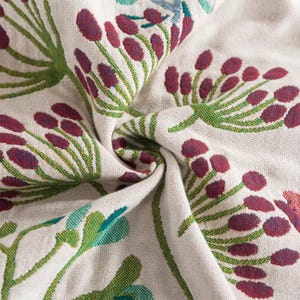 May include: White fabric with a floral pattern featuring burgundy and green flowers. The fabric is soft and textured.
