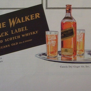 May include: A black and gold label for Johnnie Walker Black Label Blended Scotch Whisky. The label reads "12 Years Old 86.8 Proof". A bottle of Johnnie Walker Black Label Scotch Whisky is on a silver tray with three glasses filled with ice and liquid.