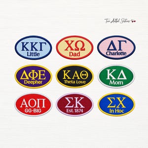May include: Nine oval-shaped embroidered patches featuring Greek letters and text. The patches include KKG Little, XΩ Dad, ΔΓ Charlotte, ΔΦΕ Deepher, KAΘ Theta Love, ΚΔ Mom, ΑΟΠ GG-BIG, ΣΚ Est. 1874, and ΣΧ In Hoc in various colors and borders.