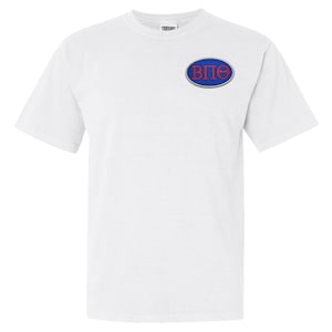 May include: A white t-shirt featuring a small embroidered emblem on the chest. The emblem is an oval shape with a blue border, and the letters "B", "&Pi;", and "&Theta;" in red. The shirt has short sleeves and a crew neck.