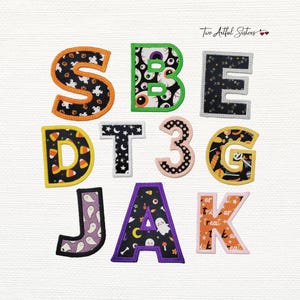 May include: A collection of fabric applique letters and numbers featuring various Halloween-themed patterns including ghosts, eyeballs, candy corn, and stars. Each character has a stitched border in colors like orange, green, yellow, and purple.