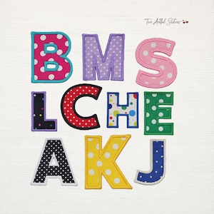 May include: A collection of fabric alphabet letters featuring various polka dot patterns in colors including pink, purple, red, green, black, yellow, and blue. Each letter has a stitched border and the text Two Artful Sisters is visible.