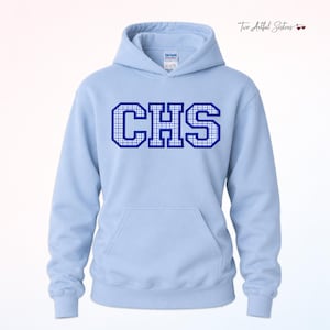 May include: A light blue hooded sweatshirt featuring the letters CHS in a dark blue and white checkered pattern across the chest. The garment includes a front kangaroo pocket, long sleeves, and a drawstring hood with a visible brand label at the neck.