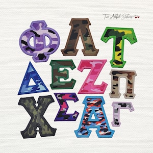 May include: A collection of embroidered Greek letters in various colors and camouflage patterns. The letters include purple, brown, green, pink, blue, and orange, with a black border. The text "Two Artful Sisters" is in the top right corner.