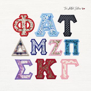 May include: A collection of nine Greek letter patches featuring various fabric patterns including floral, paisley, plaid, and polka dot designs. Each letter is outlined with a stitched border. The text Two Artful Sisters is visible in the top right corner.