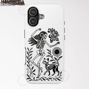 May include: White iPhone 17 case featuring a black skeleton design with the text "Not Like Other Girls." The design includes a skeleton dancing with a sunflower, a skeleton cat, and floral elements.