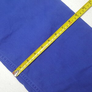 May include: Close-up of a vibrant blue fabric with a yellow measuring tape laid across it. The tape shows measurements in inches, highlighting the fabric's dimensions. The fabric's texture and color are clearly visible, showcasing its quality.