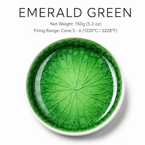 May include: A circular container of Emerald Green ceramic glaze featuring a crackle finish and a leaf vein pattern. The text reads: Emerald Green, Net Weight: 150g (5.3 oz), Firing Range: Cone 5 - 6 (1220°C / 2228°F). The glaze has a vibrant green hue.