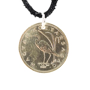 May include: A gold-colored coin necklace featuring a Hungarian 1 Forint coin with a heron on the front. The coin is dated 1997 and has the text "MAGYAR KÖZTÁRSASÁG" around the edge.