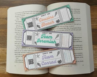 Peut inclure: Trois marque-pages colorés en forme de billets avec les phrases "Cousins Beach", "Team Jeremiah" et "Team Conrad". Chaque billet comporte un code QR, un coquillage, une étoile de mer et une illustration de cornet de glace. Les marque-pages sont sur un livre ouvert.