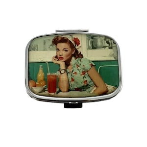 Könnte beinhalten: Ein silberner Kompaktspiegel mit einer Retro-Dinerszene. Das Bild zeigt eine Frau in einem Oberteil mit Blumenmuster, rotem Lippenstift und Kopftuch, die an einem Tisch mit einem Getränk und Obst sitzt. Der Kompaktspiegel hat eine rechteckige Form.