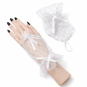 Könnte beinhalten: Weiße, fingerlose Spitzenhandschuhe mit zartem Netzmuster, verziert mit kleinen Schleifen und Rüschenkanten. Ein passendes Armband mit Kordelzugverschluss ist ebenfalls enthalten. Die Handschuhe sind im romantischen und eleganten Stil gehalten.