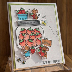 May include: A handmade greeting card featuring a large jar filled with strawberries. Adorable cartoon mice are scattered around the jar, some holding strawberries. A bee flies nearby. The card has the text "Pick Your Own" and "You Are Special".