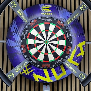 Peut inclure: Un jeu de fléchettes avec un motif cible noir, rouge, vert et blanc. Le tableau a un fond bleu et jaune avec le texte "TARGET" et "MICHAEL VANGERWEN". Quatre supports noirs avec le numéro "3" sont attachés.