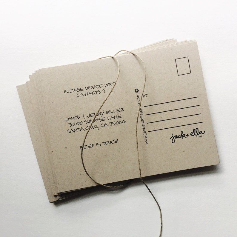 May include: A stack of brown kraft paper postcards with a twine string tied around them. The front of the postcard has the text "PLEASE UPDATE YOUR CONTACTS :)" and "JAROD & JENNY MILLER 3200 SUNRISE LANE SANTA CRUZ, CA 95064 KEEP IN TOUCH!" The back of the postcard has a white rectangle for the address and the text "www.jackandellapaper.com" and "jack+ella PAPER".