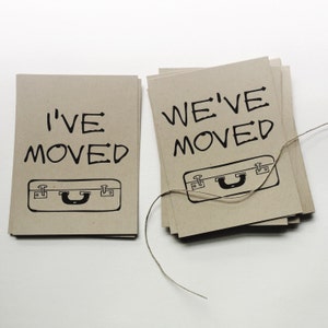 May include: Two brown cards with black text and a black suitcase graphic. The top card says "We've Moved" and the bottom card says "I've Moved".