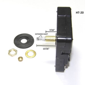 May include: Black clock movement with a 7/16 inch extended shaft and a 13/16 inch overall length. The movement is labeled HT-20. The image also shows a black washer, a gold nut, a gold washer, and a gold pin.