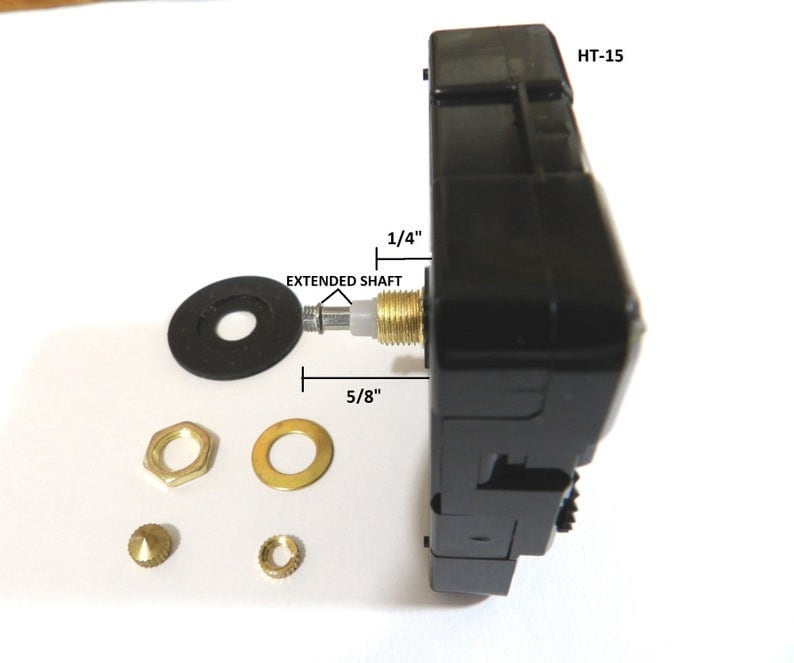 May include: Black clock movement with a 5/8 inch extended shaft and a 1/4 inch shaft. The movement is labeled HT-15. The image also shows a black washer, two gold-colored washers, a gold-colored nut, and a gold-colored pin.