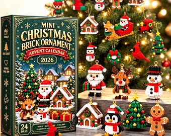 May include: A 2026 Mini Christmas Brick Ornament Advent Calendar box featuring 24 days of building projects, displayed with various assembled brick ornaments including Santa, snowmen, reindeer, trees, and houses on a wooden surface.