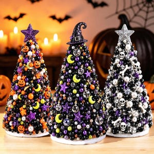 May include: Three cone-shaped decorative trees covered in beads and charms. The left tree features orange pumpkins and a purple star. The centre tree has a witch hat, moons, and stars. The right tree displays white skulls and bones with a silver star.