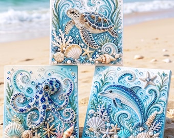 May include: Three square canvas art pieces featuring sea life designs created with rhinestones and beads. The top canvas shows a sea turtle, the bottom left an octopus, and the bottom right a dolphin, all surrounded by shells and coral.