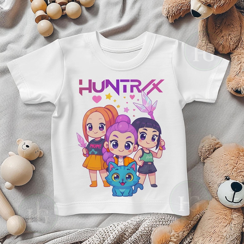 Pu&ograve; includere: T-shirt bianca con la scritta "HUNTRAX" in viola e una grafica di tre ragazze dei cartoni animati e un gatto blu. Le ragazze indossano gonne e tengono in mano oggetti a forma di cristallo. La maglietta &egrave; realizzata in un materiale morbido e confortevole.