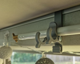 May include: A gray plastic hook with a white metal rod attached to the ceiling. The hook is designed to hold items like clothes or towels.
