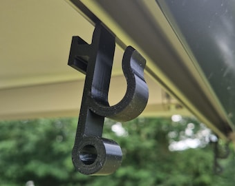 May include: A black plastic hook designed to hang items from a tent awning.