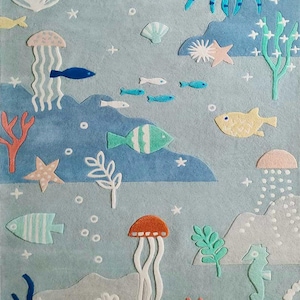 May include: A blue and white rug with a sea life theme. The rug features jellyfish, fish, starfish, seahorses, and coral. The rug is perfect for a child's room or playroom.