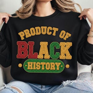May include: Black sweatshirt featuring the text "PRODUCT OF BLACK HISTORY" in a textured design. The text is in yellow, red, and green, with a green and yellow border.