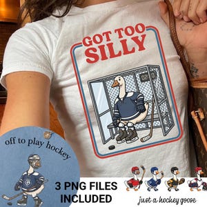 Może przedstawiać: Biały t-shirt z grafiką gęsi w stroju hokejowym i na łyżwach, siedzącej na ławce kar z napisem GOT TOO SILLY. Projekt zawiera kij hokejowy, krążek oraz dodatkowe ilustracje gęsi umieszczone w dolnej części grafiki.
