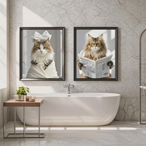 May include: Two framed cat portraits in a bathroom setting. One cat wears a bow and is wrapped in a white towel. The other cat wears glasses and reads a newspaper with the text "HAT'S COLETTO".
