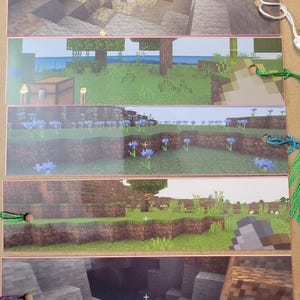 May include: Set of five Minecraft-themed bookmarks. Each bookmark features a different scene from the game, including landscapes with trees, flowers, and caves. The bookmarks are made of a sturdy material and have colorful string tassels.