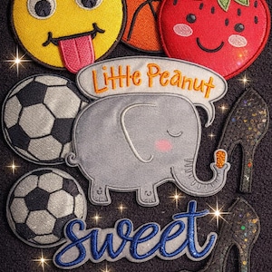 Puede incluir: Parches bordados que incluyen un emoji amarillo, una pelota de baloncesto, una fresa sonriente, balones de fútbol, un elefante gris con "Little Peanut", un par de tacones altos y la palabra "Sweet".
