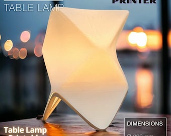 Pode incluir: Uma lâmpada de mesa de origami branca impressa em uma impressora 3D. A lâmpada tem a forma de uma estrela e emite um brilho quente. A lâmpada tem um diâmetro de 20 cm e uma altura de 25 cm. O texto "ORIGAMI TABLE LAMP" e "3D PRINTER" está no topo da imagem. O texto "Table Lamp Printable STL File" está na parte inferior esquerda da imagem. O texto "DIMENSIONS Ø 200 mm H 250 mm" está na parte inferior direita da imagem.