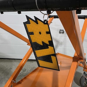 May include: A black and orange metal cart with a black and yellow tag that says "LIZ" hanging from it.