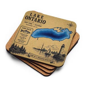 Puede incluir: Un juego de cuatro posavasos cuadrados con un mapa del lago Ontario. El posavasos superior es de color canela con una ilustración azul del lago y el texto "Lake Ontario" y "Lake of a Thousand Beauties". Los posavasos tienen respaldo de corcho.