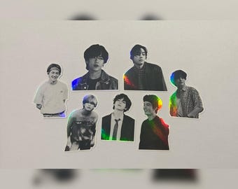 May include: A set of seven black and white holographic stickers featuring different images of men. The stickers are on a white background.