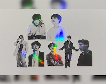 May include: A set of seven holographic stickers featuring black and white images of seven different people. The stickers are on a white background.