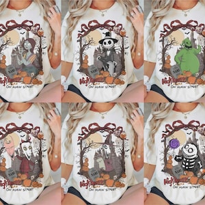 Może przedstawiać: Biały t-shirt z sześcioma wariantami nadruku graficznego z ciemną ramką, dyniami, nagrobkiem z napisem NAME oraz tekstem Nightmare On Main Street. Każdy wz&oacute;r przedstawia inną postać z filmu animowanego o tematyce grozy.