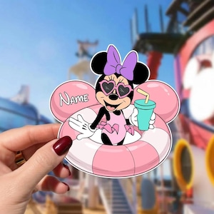 May include: A Minnie Mouse sticker in a pink and white striped inner tube, wearing heart-shaped sunglasses and a purple bow. She holds a teal drink with a yellow straw. The sticker has the word "NAME" on a pink bubble.