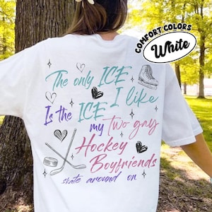 May include: White t-shirt with the text "The only ICE I like is the ICE my two gay Hockey Boyfriends skate around on." The shirt also features a hockey puck, hockey sticks, and a figure skate.
