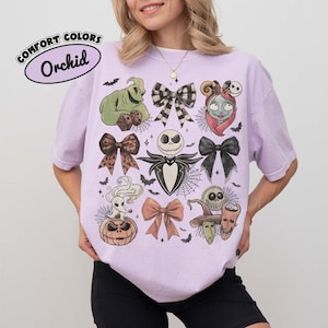 Puede incluir: Una camiseta de color morado claro con un estampado gr&aacute;fico de personajes y lazos de Pesadilla antes de Navidad. El dise&ntilde;o incluye a Jack Skellington, Sally, Oogie Boogie, Zero y varios lazos, junto con el texto Comfort Colors Orchid.